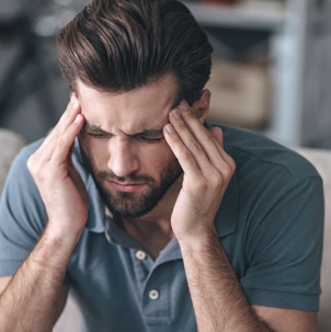 Man holds head in pain